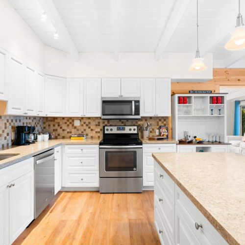 Welcome to your dream kitchen getaway! With bright white cabinets and a spacious countertop, this cozy space is perfect for whipping up delicious meals or enjoying a cup of coffee.
