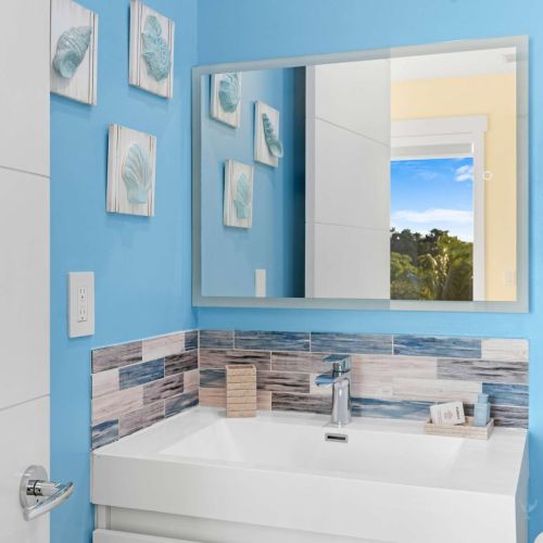 Step into this spacious bathroom retreat where you can admire your reflection in the grand mirror while enjoying a relaxing soak in the tub.