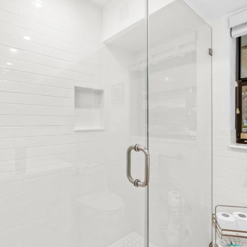 Clean, bright bathroom with a walk-in shower and a view of the water while you get ready.