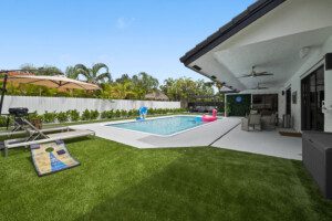 Luxurious backyard of Villa Paradise with a pristine pool, lounge chairs, and a lush tropical backdrop.