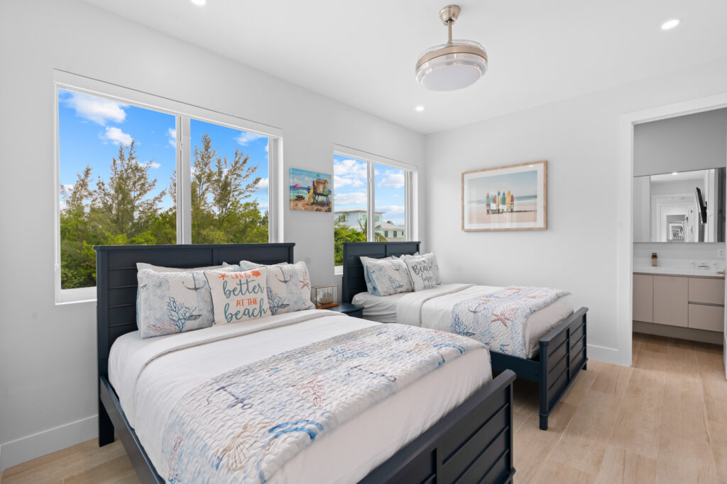 Bright and cozy bedroom with two beds at Emerald Oasis in Marathon, Florida, offering a serene view and comfortable accommodations for vacation rentals.