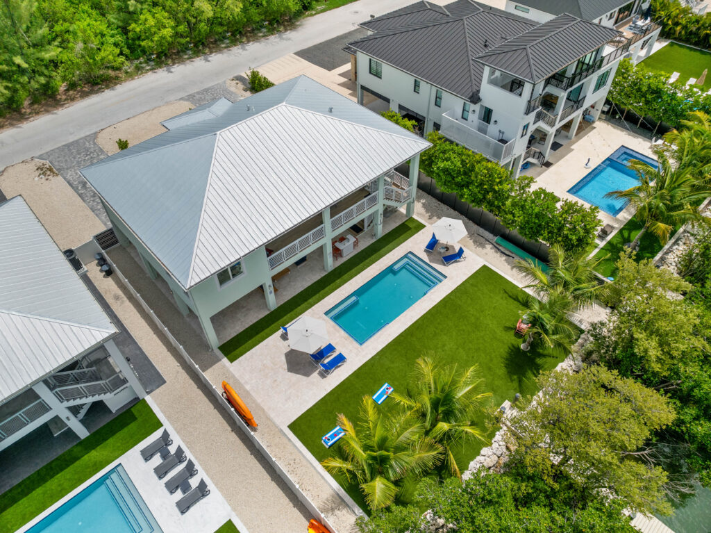 Aerial view of Emerald Oasis in Marathon, Florida, featuring a private pool, lush yard, and spacious outdoor living areas, perfect for vacation rentals.