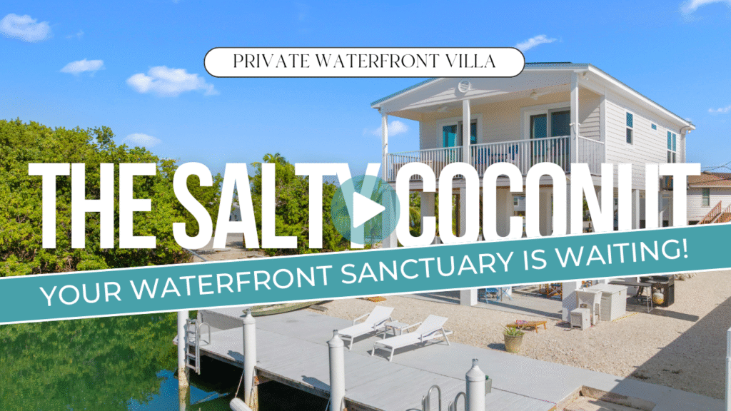 A modern white waterfront villa with a dock and lounge chairs, surrounded by greenery and clear skies. Text reads: the salty coconut - your waterfront sanctuary is waiting! Private marathon fl monthly rental villa.