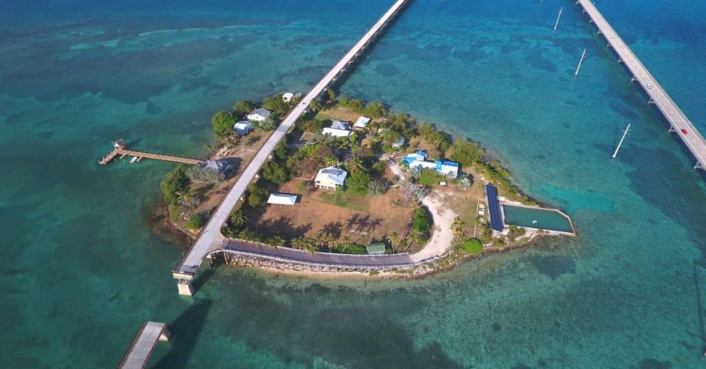 8 day trips from marathon fl you didn't know existed (2026) 3 A small island with several buildings, surrounded by clear blue water, is connected to land by two long bridges. The island has docks, trees, and open spaces, with roads leading to and from the island.