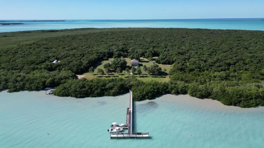 8 day trips from marathon fl you didn't know existed (2026) 6 A long wooden pier extends over turquoise water to a lush, green island with a few buildings and open grassy areas, surrounded by dense forest and calm sea under a clear blue sky.